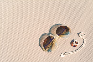 Photo of Stylish sunglasses and jewelry on grey surface, flat lay. Space for text