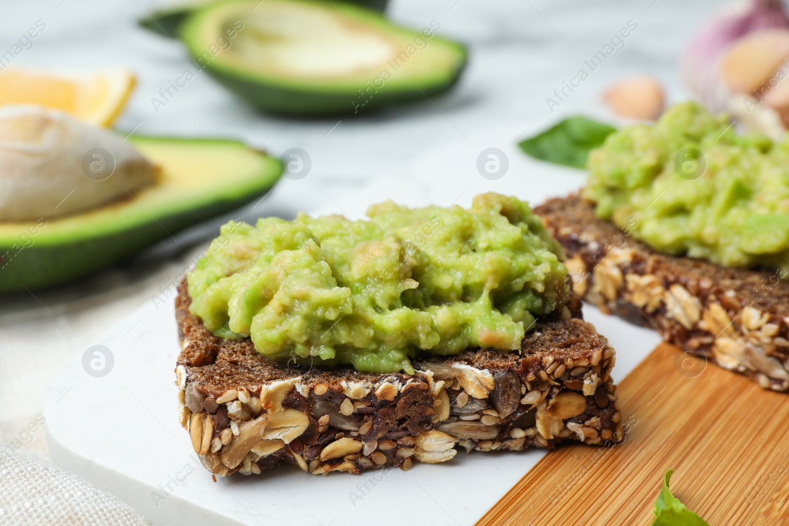 Photo of Tasty sandwiches with avocado spread on table, closeup