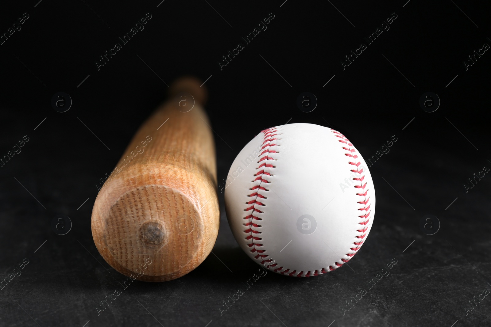 Photo of Baseball bat and ball on black background. Sports equipment