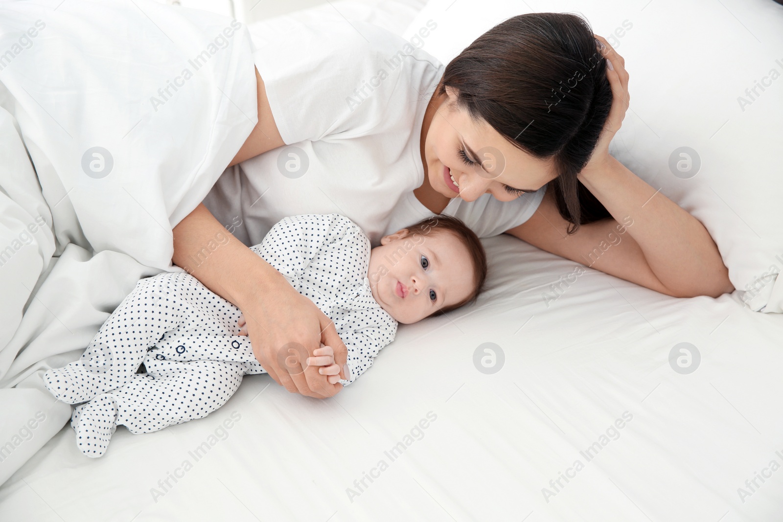 Photo of Happy woman with her cute baby on bed