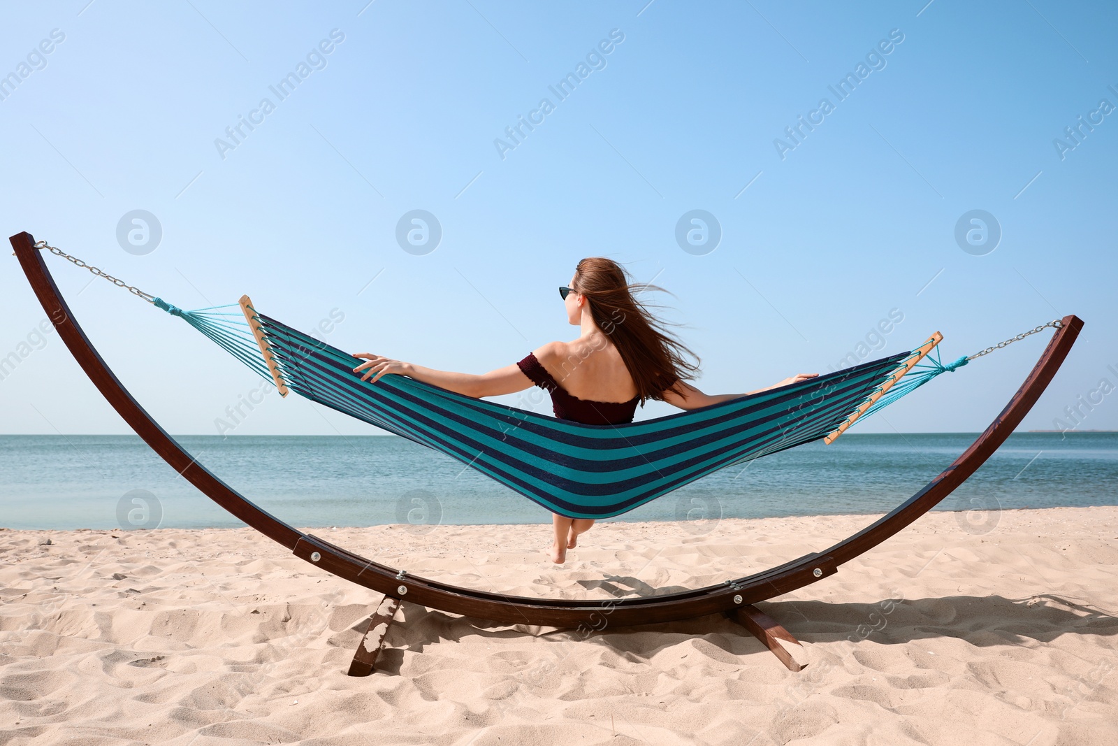 Photo of Young woman relaxing in hammock on beach