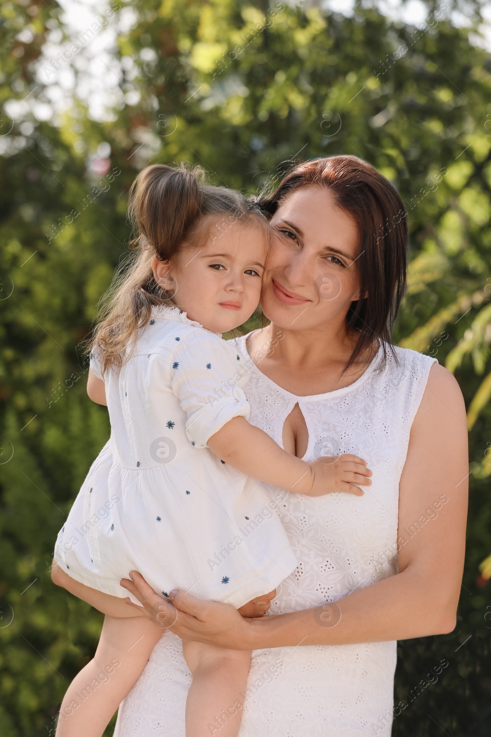 Photo of Portrait of happy mother with her cute daughter in park