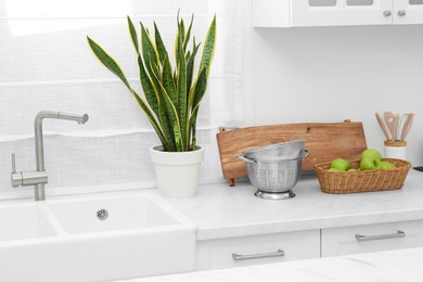 Photo of Modern sink and water tap in kitchen. Interior design