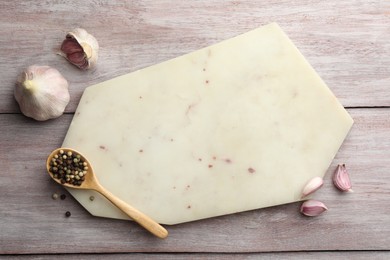 Photo of Cutting board, pepper and garlic on light wooden table, flat lay. Space for text