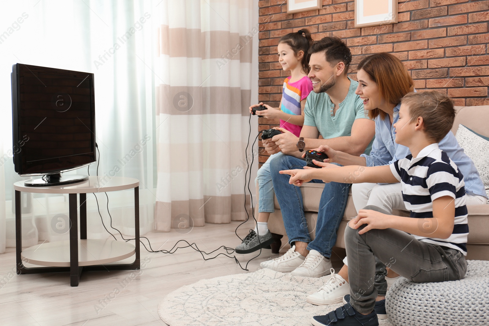 Photo of Happy family playing video games in living room