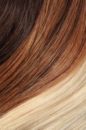 Photo of Strands of different color hair as background, closeup