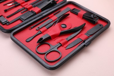 Photo of Kit of pedicure tools on beige background, closeup