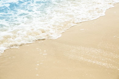 Photo of Sea waves rolling on beautiful sandy beach, closeup. Summer vacation