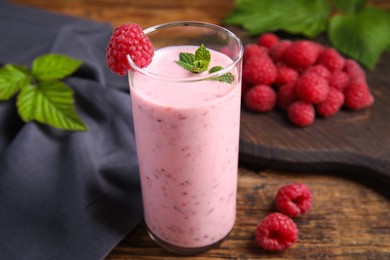 Photo of Glass of tasty fresh raspberry smoothie on wooden table