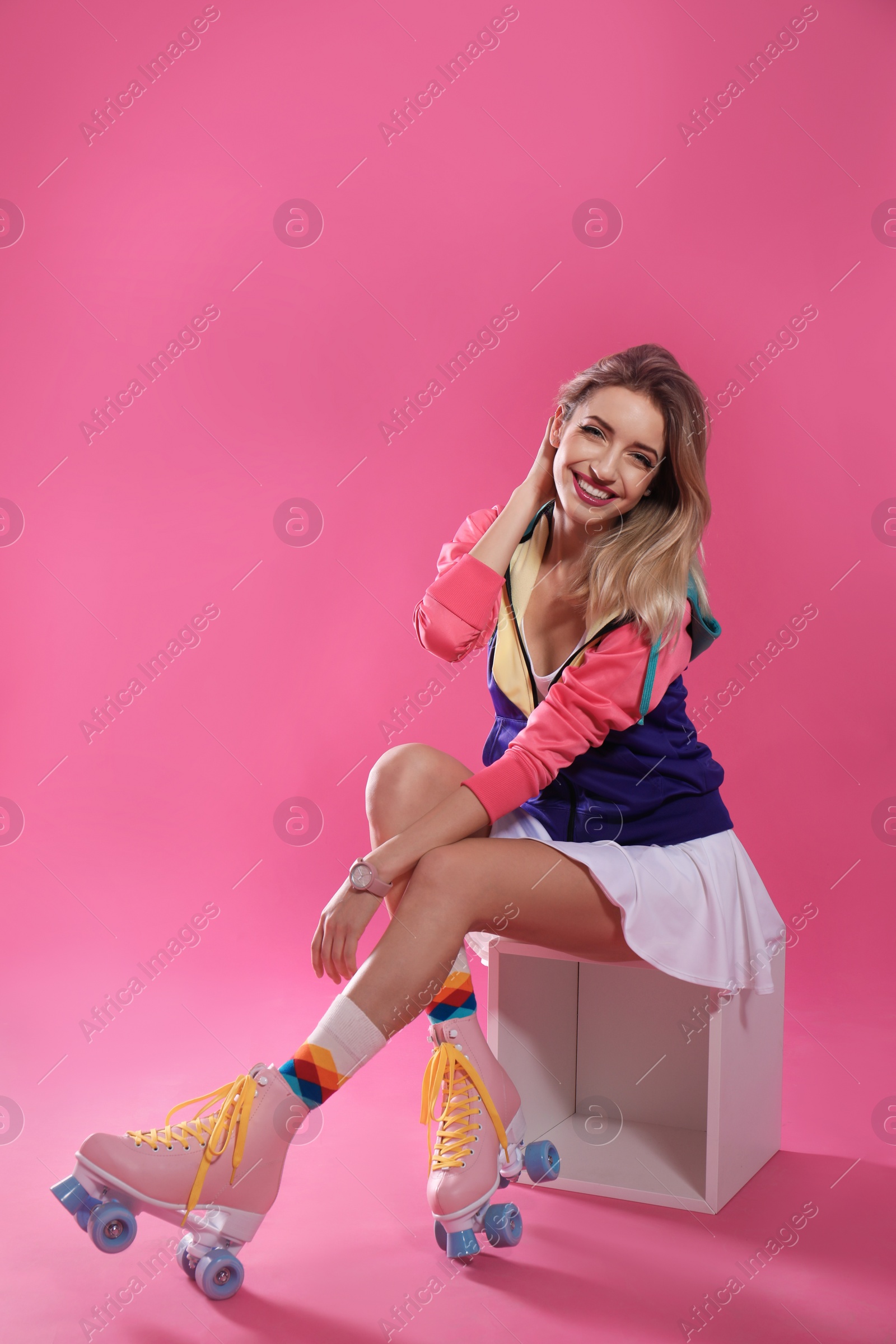 Photo of Young woman with retro roller skates on color background