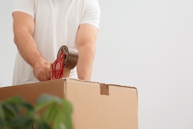 Man packing carton box indoors, closeup. Moving day