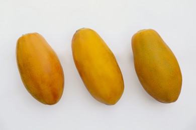 Photo of Fresh ripe papaya fruits on white background, flat lay