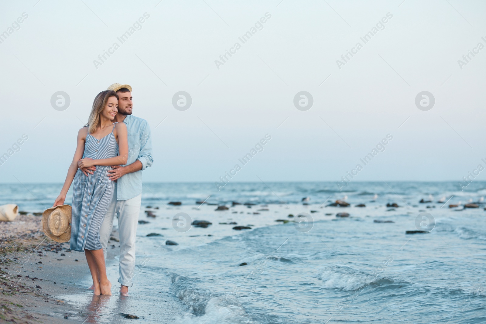 Photo of Young couple spending time together on beach