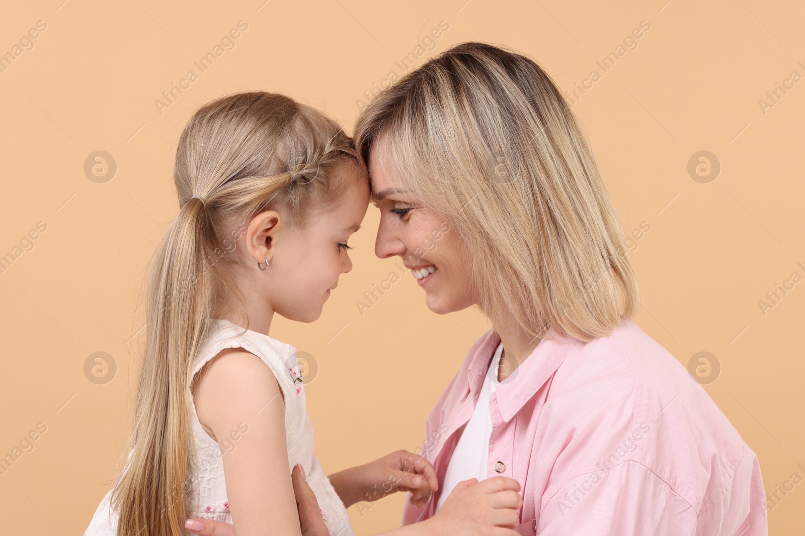 Photo of Family portrait of happy mother and daughter on beige background