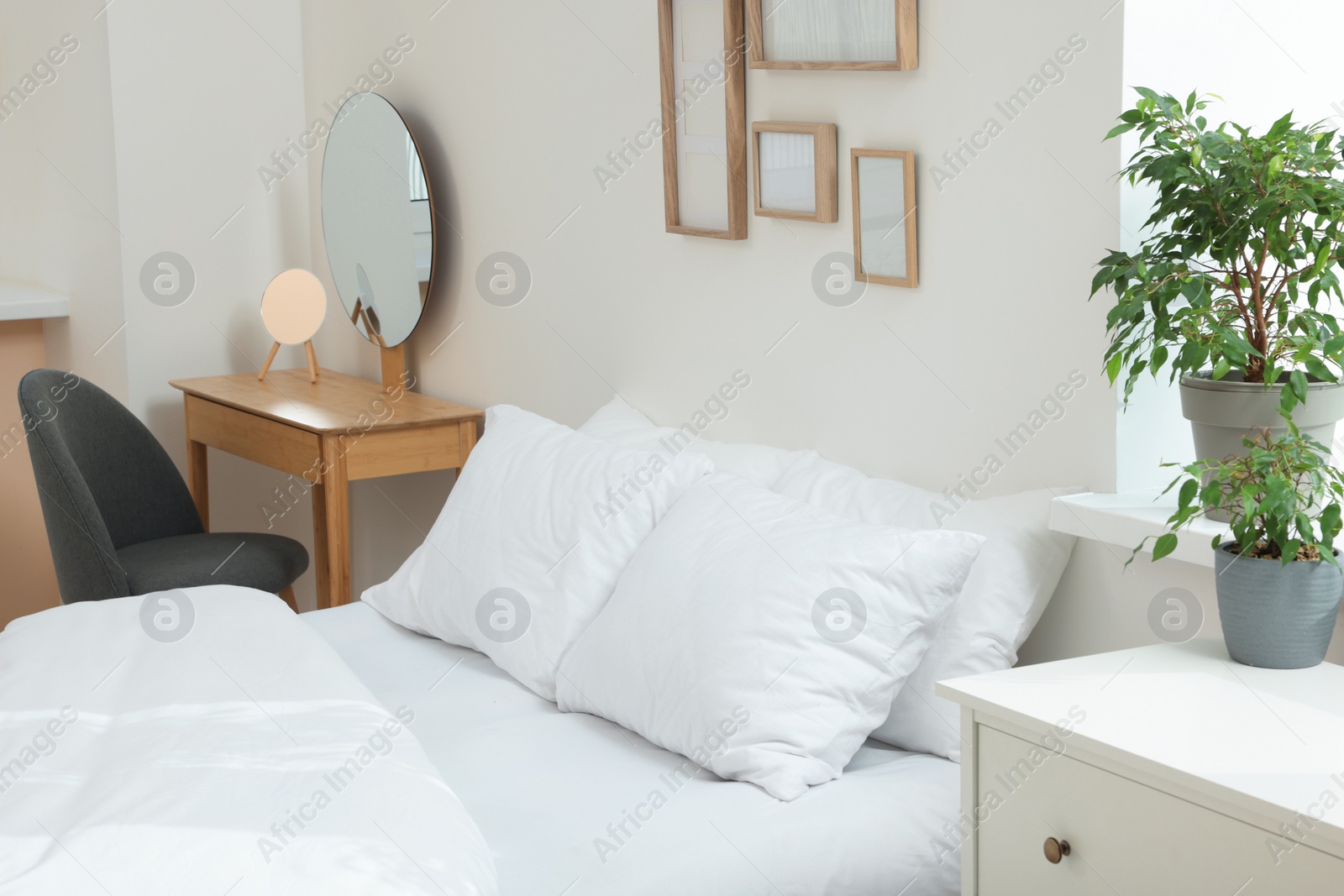 Photo of Bed with soft white pillows in cozy room interior