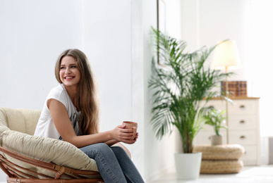 Young woman resting in armchair at home