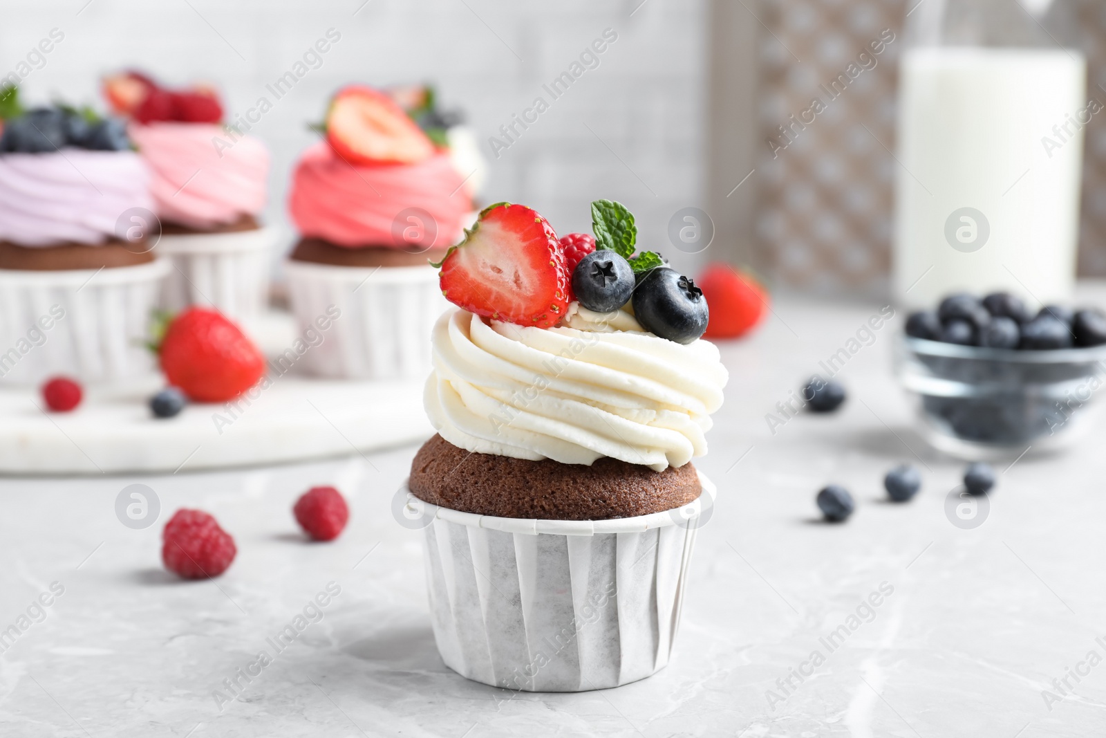 Photo of Sweet cupcake with fresh berries on light table