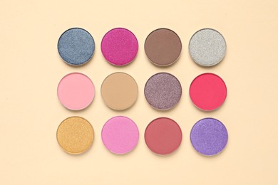 Photo of Different beautiful eye shadows on beige background, flat lay