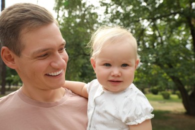 Photo of Father with his cute baby spending time together outdoors