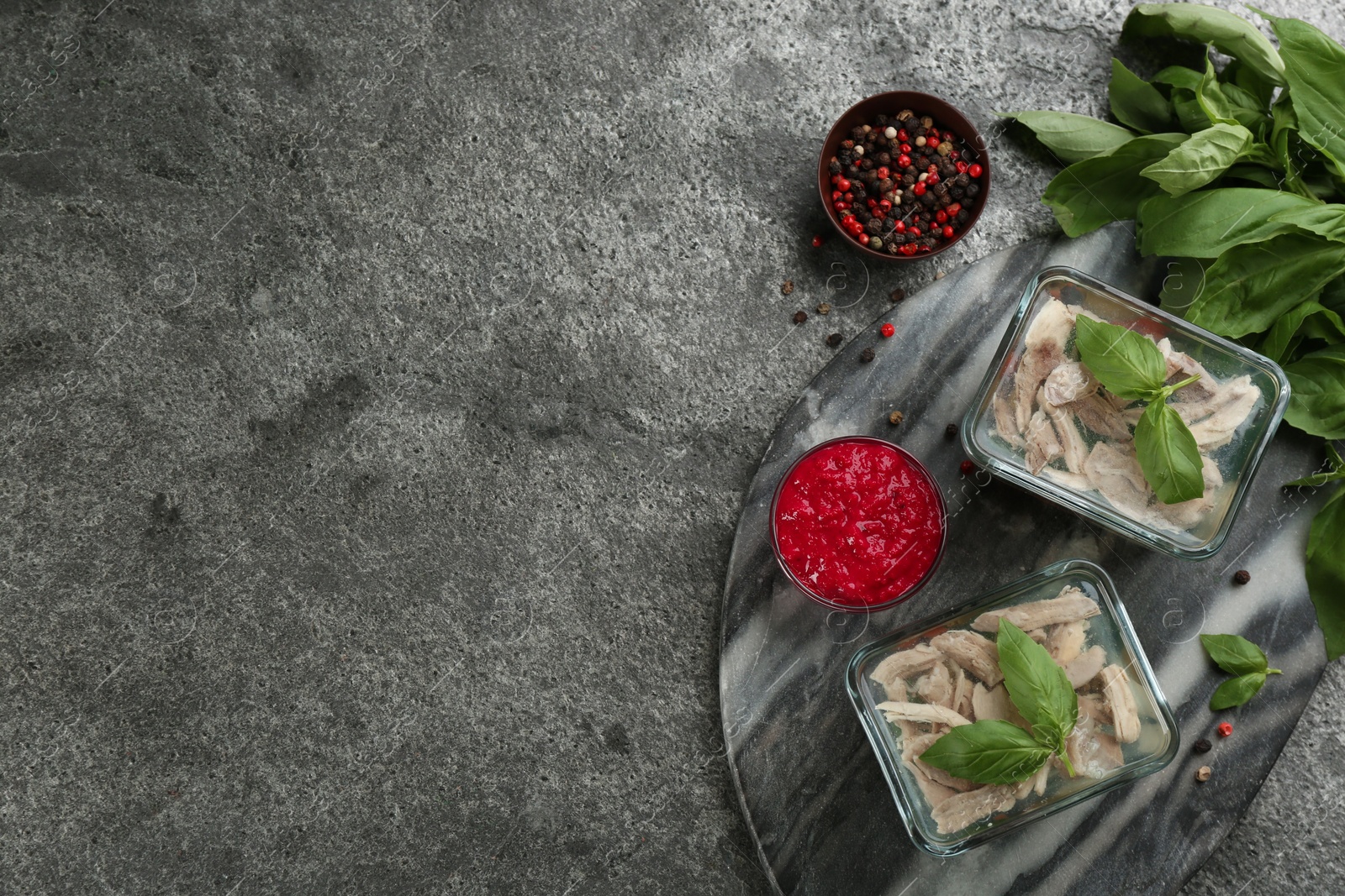 Photo of Delicious aspic with meat and vegetables served on grey table, flat lay. Space for text