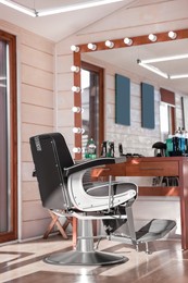 Photo of Stylish hairdresser's workplace with professional armchair in barbershop