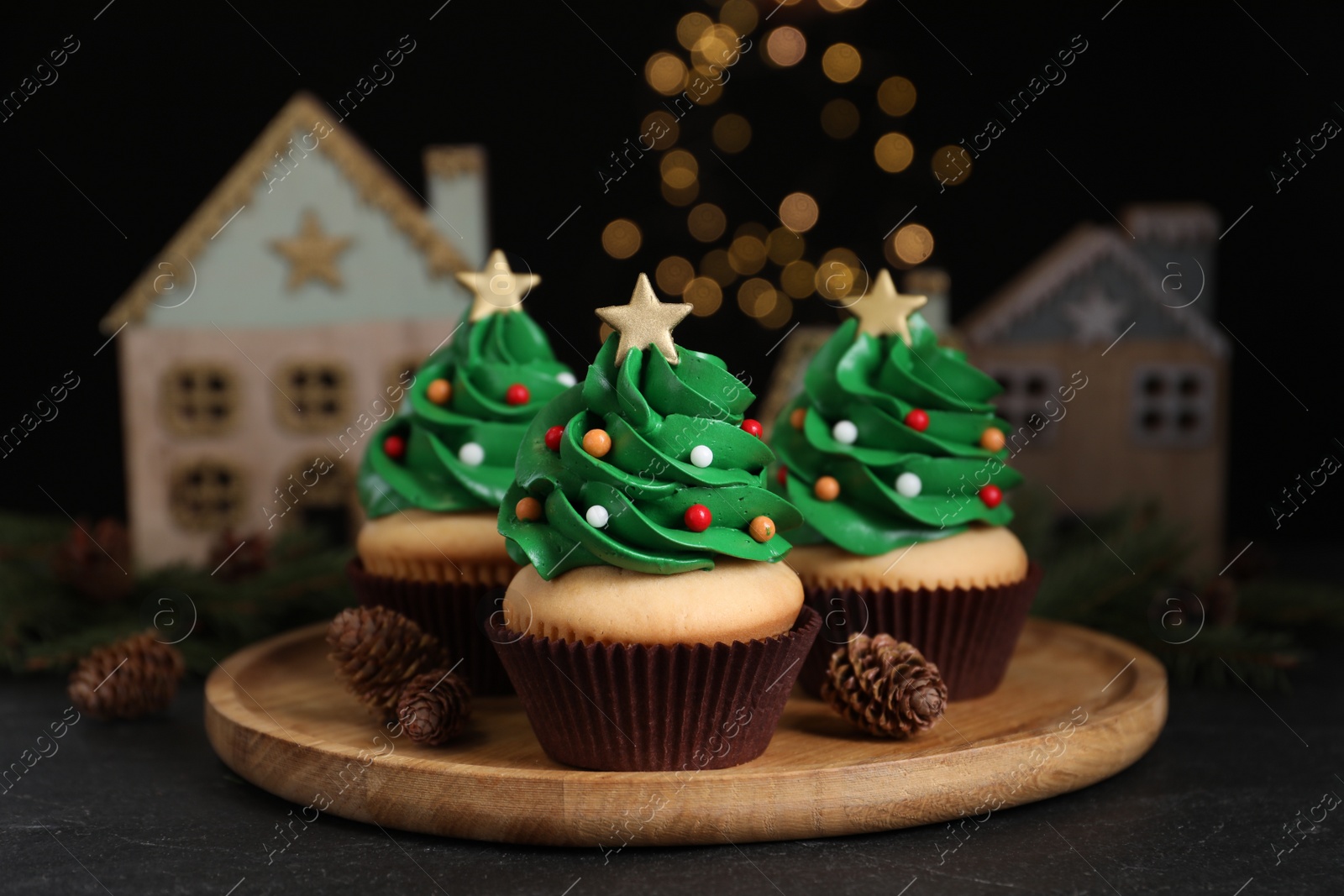 Photo of Christmas tree shaped cupcakes on black table