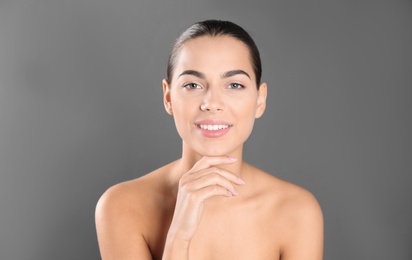 Photo of Portrait of beautiful young woman on grey background. Lips contouring, skin care and cosmetic surgery concept