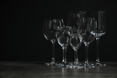 Photo of Set of bar glassware on table against dark background