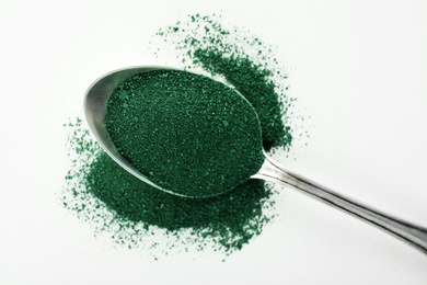 Spoon with spirulina algae powder isolated on white, top view