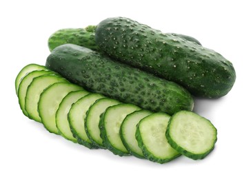 Photo of Whole and cut cucumbers on white background