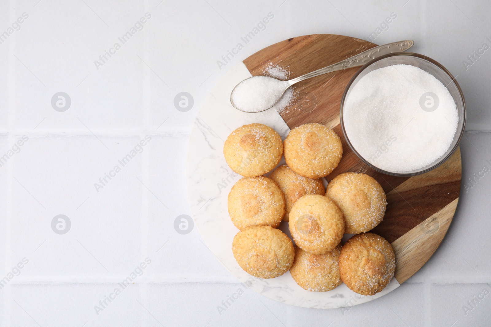 Photo of Tasty sweet sugar cookies on white tiled table, top view. Space for text