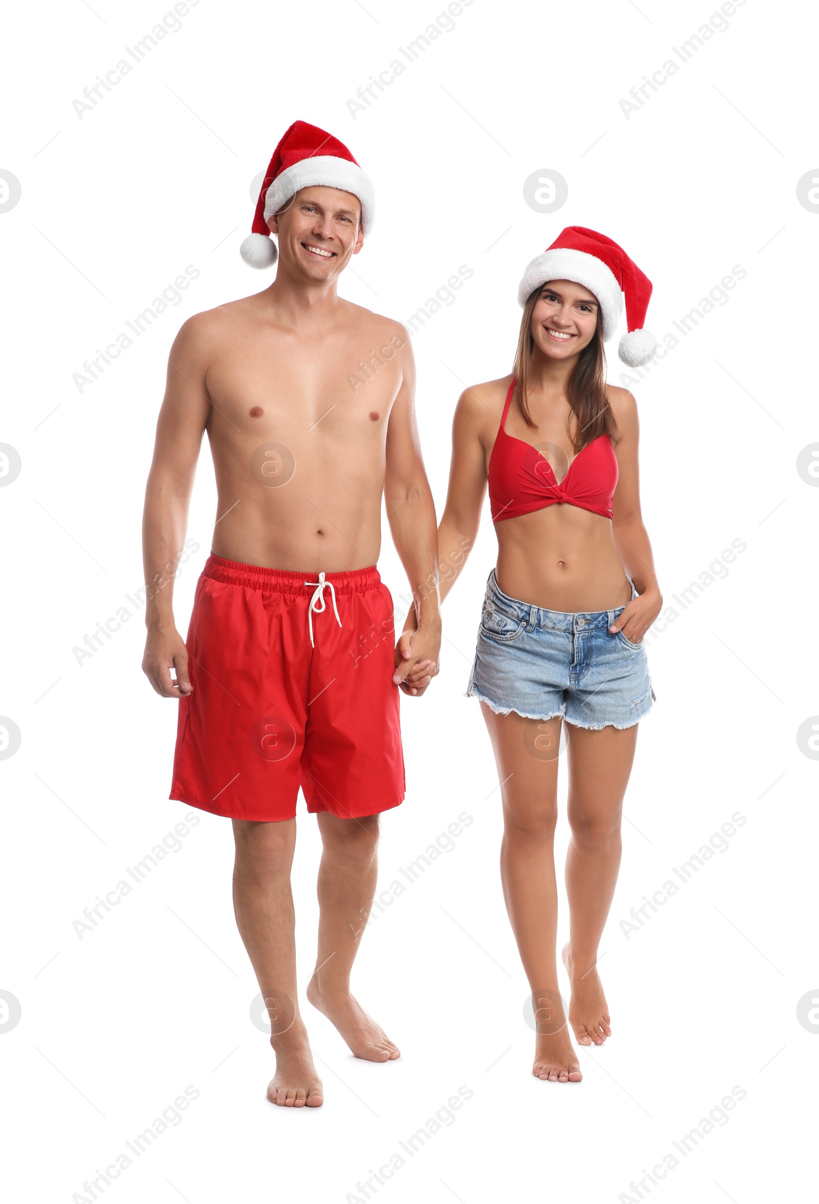 Photo of Happy couple with Santa hats together on white background. Christmas vacation