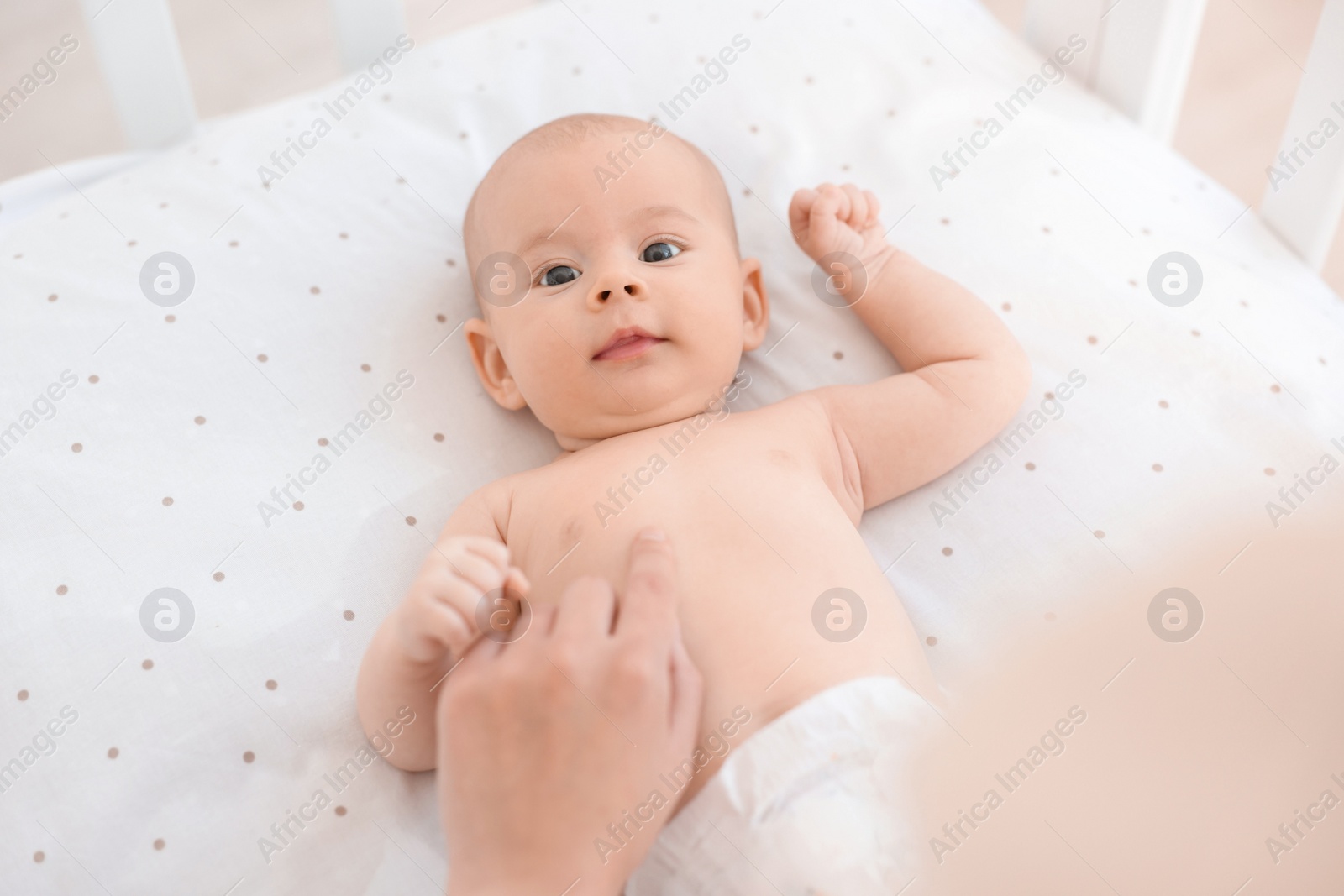 Photo of Mother with her cute little baby in crib