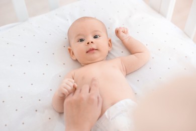 Photo of Mother with her cute little baby in crib