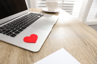 Photo of Red heart on laptop in office. Valentine's day celebration