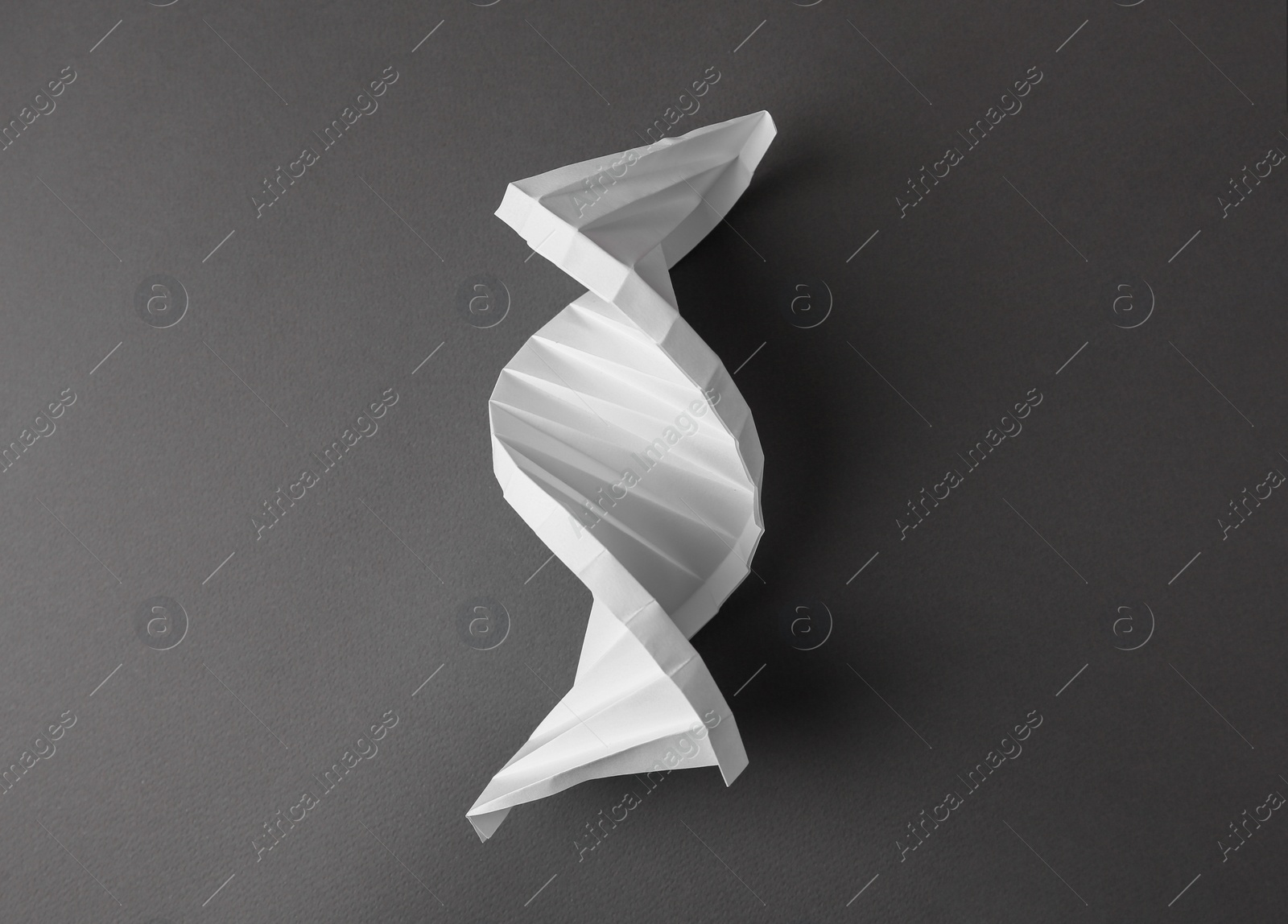 Photo of Paper model of DNA molecular chain on black background, top view