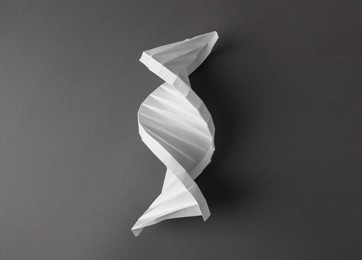 Paper model of DNA molecular chain on black background, top view