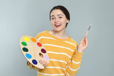 Woman with painting tools on grey background. Young artist