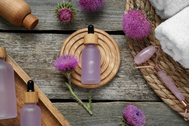 Photo of Flat lay composition with essential oil and flowers on wooden background.