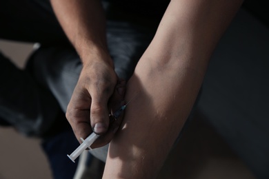 Male drug addict making injection, closeup of hands