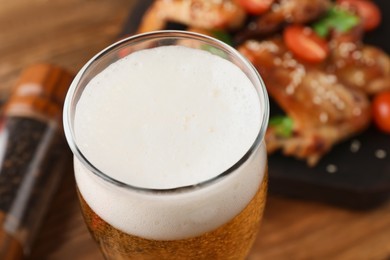 Glass of fresh beer on table, closeup view