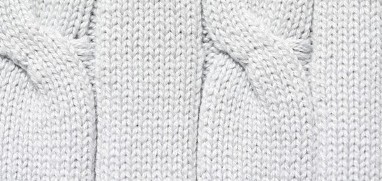 Photo of Texture of soft light knitted fabric as background, top view