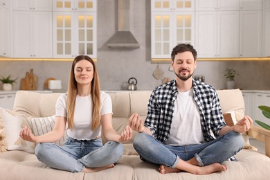 Photo of Couple meditating together at home. Harmony and zen
