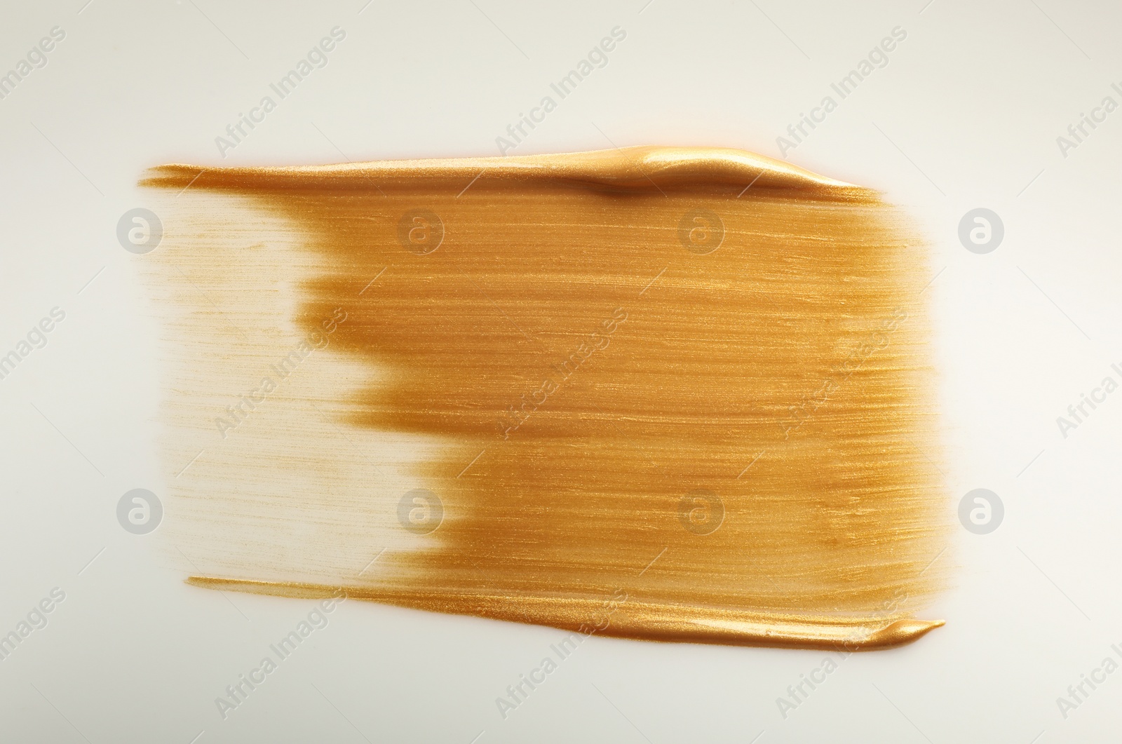 Photo of Stroke of gold paint isolated on white, top view