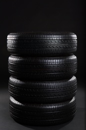 Photo of Stack of car tires on black background