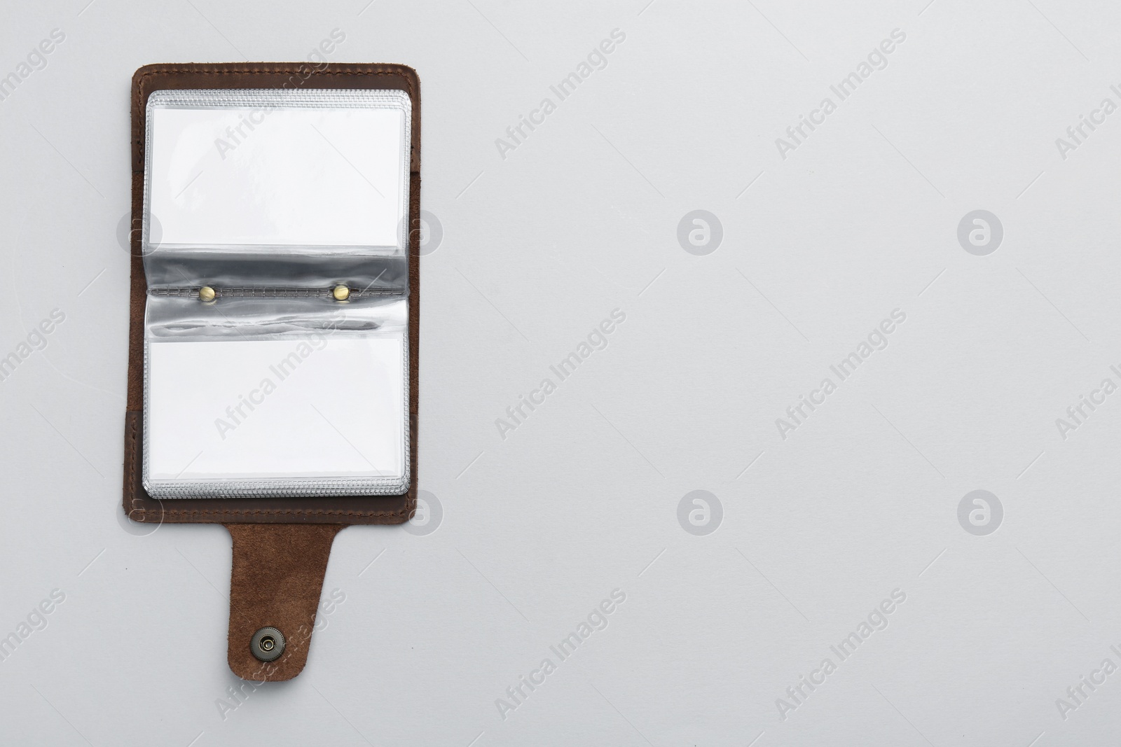 Photo of Leather business card holder with blank cards on light grey background, top view. Space for text