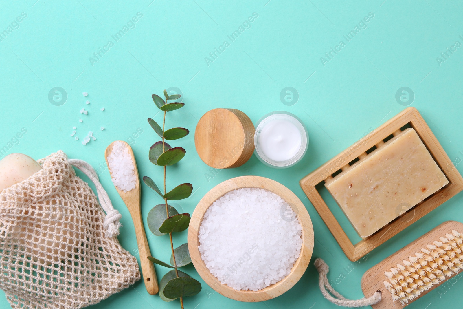 Photo of Jar of cream, body care products and eucalyptus branch on turquoise background, flat lay. Space for text