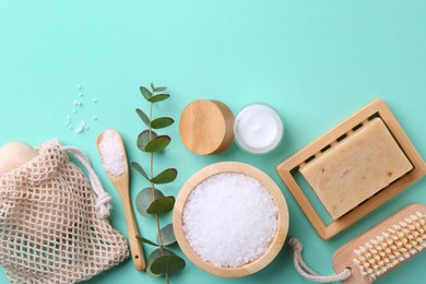 Jar of cream, body care products and eucalyptus branch on turquoise background, flat lay. Space for text