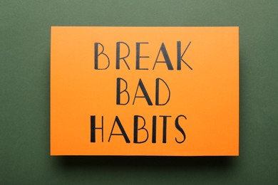Photo of Orange sheet of paper with phrase Break Bad Habits on green background, top view