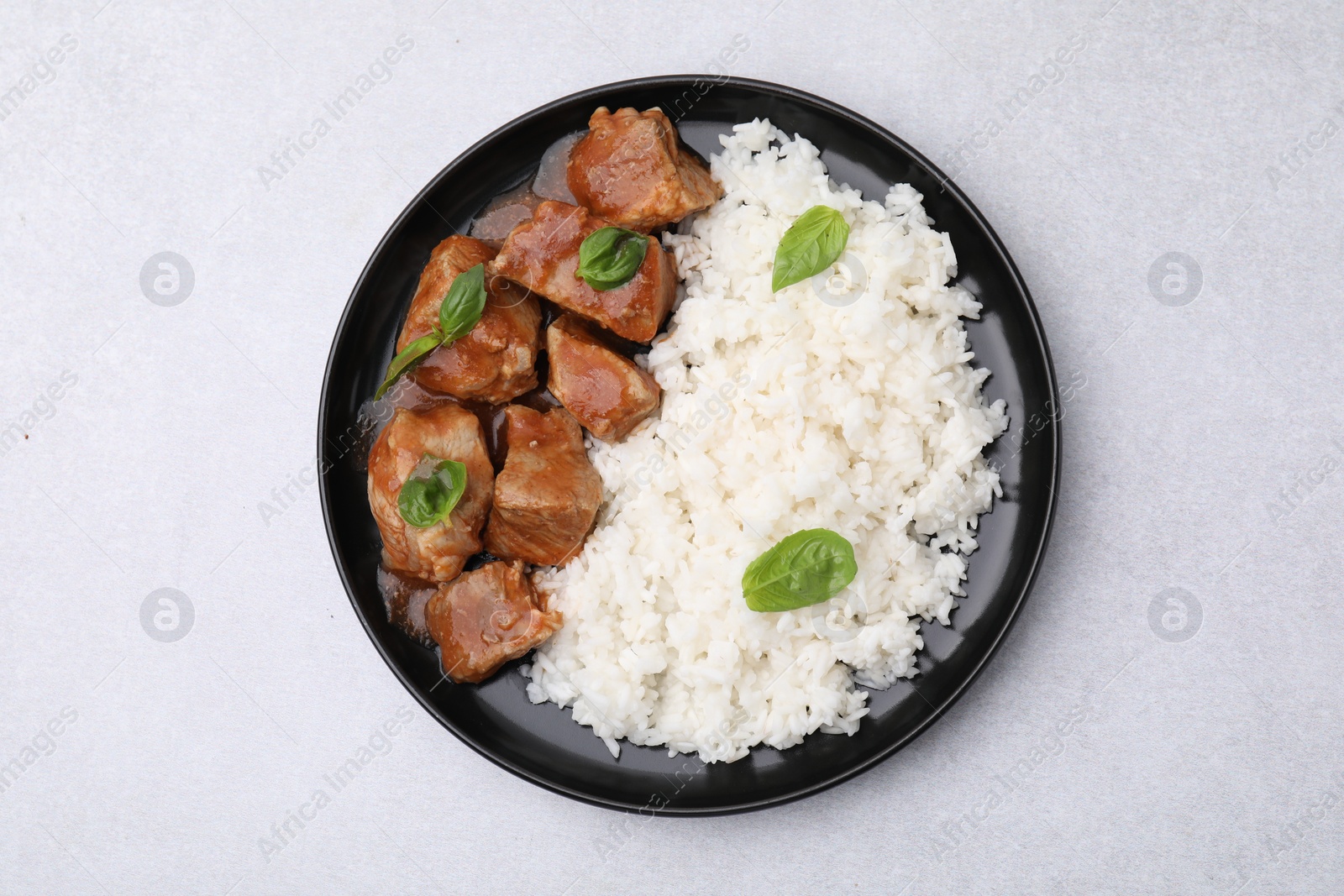 Photo of Delicious goulash with rice on light grey table, top view